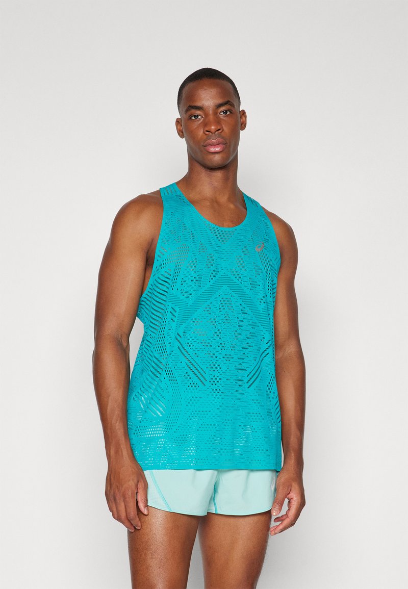 Débardeur de sport turquoise avec un motif découpé géométrique, fabriqué en tissu léger ; associé à un short bleu clair.