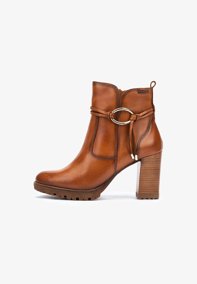 Bottines en cuir marron avec un bout arrondi, des accents en métal doré et un large talon en bois. Présente une sangle décorative.