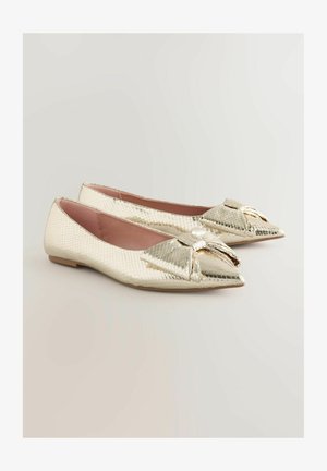 Lamedega jalatsid terava varbaga, valmistatud kuldsest metallilisest tekstuurist materjalist. Esiküljel on dekoratiivne pael ning siseruum on heledat roosat värvi.