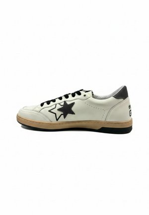 Biały niskoprofilowy sneaker z czarnym logo gwiazdy, czarnymi sznurowadłami, beżową podeszwą środkową i czarną podeszwą zewnętrzną na białym tle.