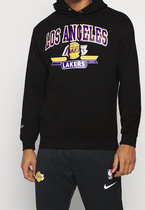Svart hoodie med "LOS ANGELES LAKERS" i gul och lila text. Tyget är mjukt, med en framficka och justerbar dragsko vid huvan.