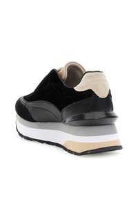 Černé a béžové tenisky s tlustou bílou, šedou a béžovou podrážkou, z pohledu zadní pravé strany na bílém pozadí.