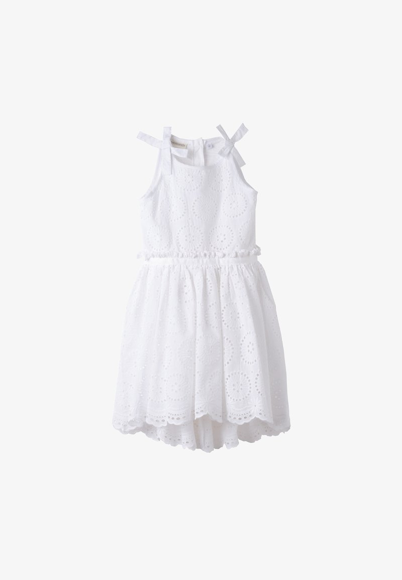 Robe blanche sans manches avec motif ajouré, taille volantée et bretelles nouées aux épaules. Jupe évasée et doublure partielle pour plus de confort.