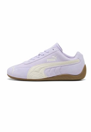 Baskets Puma violettes claires avec bande crème, logo blanc, texture en daim et semelle en caoutchouc marron clair, présentées de profil sur fond blanc.