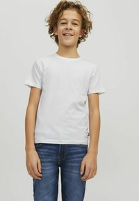 Vit kortärmad t-shirt i bomull med rund hals. Matchad med blå denimjeans med klassisk passform och synlig sömnad.