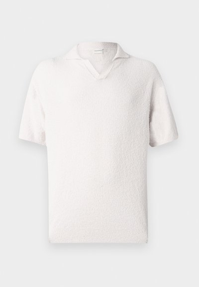 Λευκός κοντομάνικος πουλόβερ με υφασμάτινη υφή, διαθέτει γιακά σε σχήμα V και άνετη γραμμή. Το υλικό φαίνεται μαλακό και ελαφρύ.