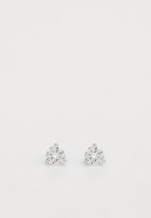 Kulaté stříbrné náušnice s jasnými, jiskřícími kameny, s fasetovým designem. Každá náušnice má tři dráty, které drží kámen bezpečně.