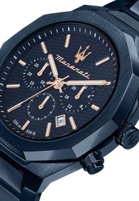Maserati Chronograph-Uhr mit einem dunkelblauen strukturierten Zifferblatt, rosevergoldeten Akzenten, achteckigem Gehäuse und einem Metallarmband; verfügt über drei Teilzifferblätter.