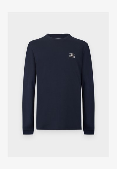 Μακρυμάνικη μπλούζα σε ναυτικό μπλε χρώμα με στρογγυλή λαιμόκοψη και μικρό λευκό λογότυπο J.LINDEBERG STOCKHOLM στο αριστερό μέρος του στήθους.