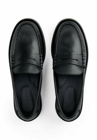 Mocasines de cuero negro con un acabado suave, acentos cosidos y un perfil bajo. Diseño deslizante con suelas interiores perforadas.