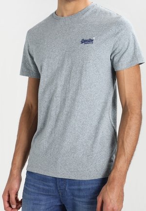 Grå meleret T-shirt med kortærmer og rund halsudskæring samt et lille blåt logo på venstre bryst. Glat tekstur, afslappet pasform, båret med denim.