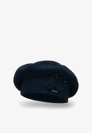 Marine strikket beret med en tekstureret blomsterdetalje med perler, samt et lille metal logo-tag på siden.