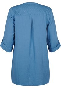 Chemise bleu clair à manches longues avec un yoke texturé et détaillé et des poignets retroussés. Tissu doux avec une coupe décontractée et un dos plissé pour plus de confort.