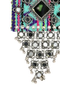 Barevná textilní kabelka s vícerozměrnou tkanou vzorovou, stříbrným kováním a reflexními ozdobami visícími ze spodní části.