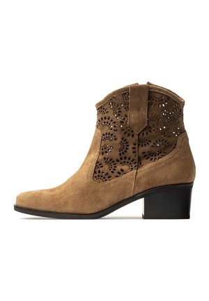 Bruine suède enkellaars met lage blokhak en bloemmotief lasergesneden geperforeerd ontwerp op de bovenzijde van de schacht.