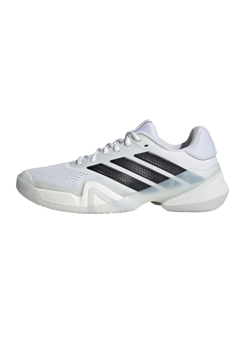 Biela športová obuv s čiernymi pruhmi, sieťovaným zvrškom, textúrovanou špičkou a priehľadnou podrážkou. Navrhnutá pre obratnosť a pohodlie.