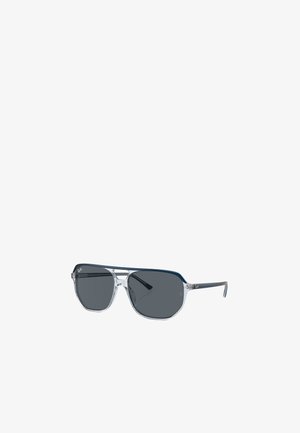 Occhiali da sole aviator con montatura trasparente, lenti grigio scuro, forma angolare e dettagli in metallo. Presentano un design a doppio ponte e un dettaglio con logo.