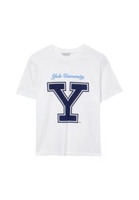 T-shirt bianco a maniche corte con "Yale University" in blu corsivo sopra una grande "Y" contornata in blu navy sul davanti.