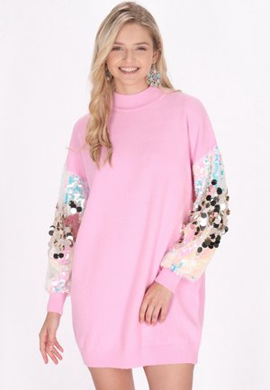 Roze trui-jurk met lange, gepaillettes mouwen met iriserende en zwarte pailletten. Gebreide textuur met geribbelde manchetten en halslijn.