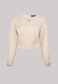 Beige lang mouwen top met een V-hals, gestructureerde stof, iets verkorte ontwerp en geplooide manchetten; bevat een ritssluiting aan de achterkant.