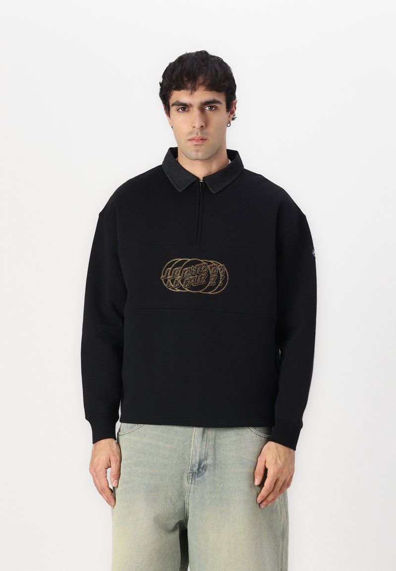 Suéter negro de pullover con cuello de cuarto de cremallera, que presenta un logo bordado en dorado en el frente y tela de cuello en gris contrastante.