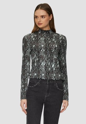 Haut à manches longues dans un motif imprimé serpent noir et gris, avec un col montant et un tissu doux et extensible. Associé à un jean noir ajusté.