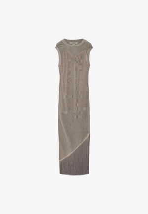 Mouwloze lange beige gebreide jurk met open gaaspatroon en diagonale franjes aan de zoom.