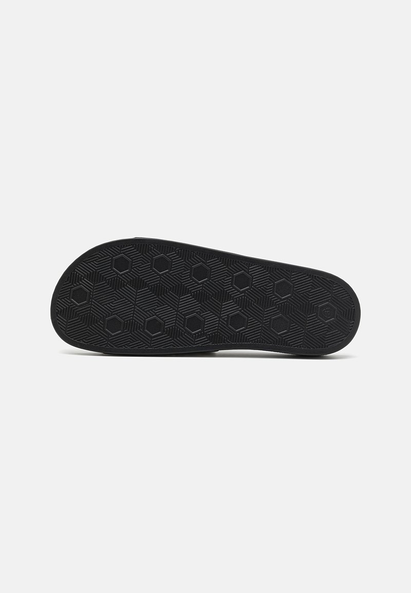 Semelle de chaussure en caoutchouc noir avec un motif hexagonal texturé pour l'adhérence, de forme courbée avec un bord lisse. Conçue pour la traction et la durabilité.