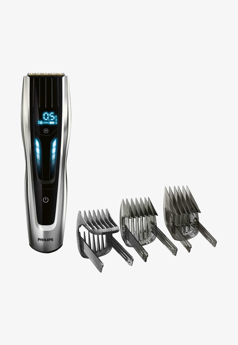 Philips haartrimmer met een zilveren en zwarte kunststof behuizing, digitaal display en drie grijze kunststof kambevestigingen voor lengteregeling.