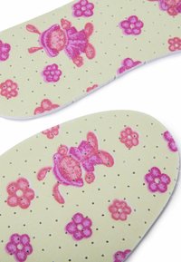 Gula innersulor med en strukturerad yta prydd med mönster av rosa kaniner och blommor, tydliga perforeringar för god ventilation.