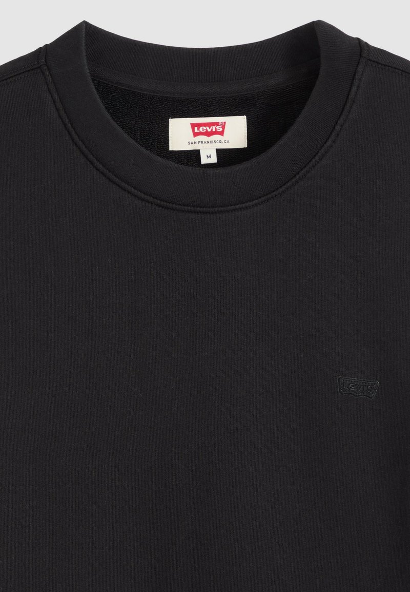Sweat-shirt noir Levi's à col rond avec petit logo brodé sur la poitrine et étiquette de taille M visible à l'intérieur du col.
