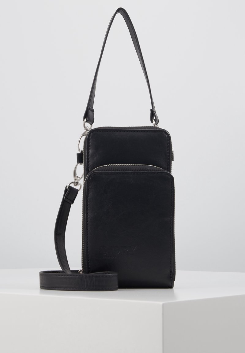 Mustasta nahasta valmistettu ristiselkkä laukku, jossa on hopeiset yksityiskohdat, kaksi vetoketjullista osiota ja säädettävä hihna. Tasainen pinta, kompakti suorakulmainen muoto.