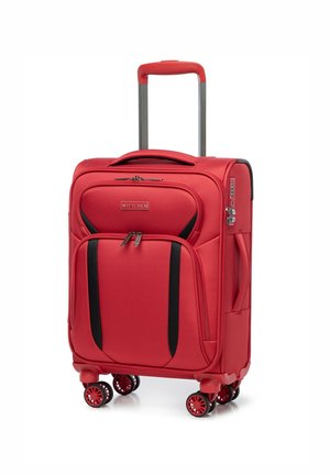 Valise rouge avec une exterior en tissu, deux zips, accents noirs, poignée rétractable, quatre roues pivotantes et poches avant pour l'organisation.