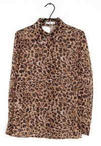 Blůza s leopardím potiskem, průhledná látka, hnědé a černé skvrny, klasický límec, dlouhé rukávy, zapínání na knoflíky vpředu, zavěšená na černém háčku.