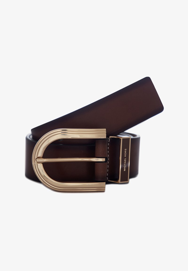 Brązowy skórzany pasek z dużą złotą, wygiętą klamrą oraz brandingiem Michael Kors na pętli paska, na białym tle.