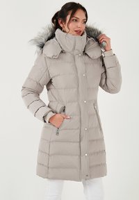 Svijetlosivi jastučić kaput s visokim ovratnikom, odvojivom lažnom krznom kapuljačom, bočnim džepovima na zip, i horizontalnom quilted teksturom.