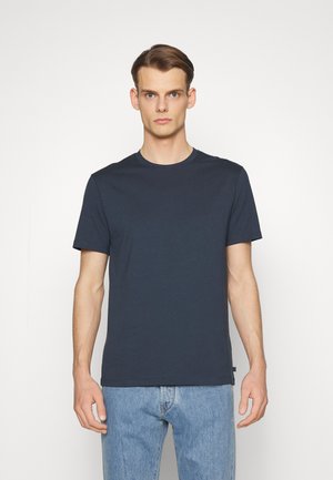 Dunkelblaues Baumwoll-T-Shirt mit Rundhalsausschnitt und kurzen Ärmeln, reguläre Passform und schlichter Gestaltung. Getragen mit hellblauen Jeans.