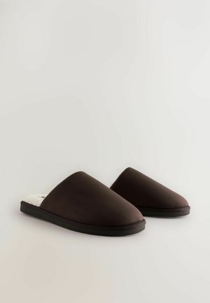 Braune Hausschuhe zum Hineinschlüpfen mit einem glatten Stoffäußeren, weicher Innenauskleidung und strukturiertem schwarzen Gummisohle. Runder Zehendesign, minimalistischer Stil.