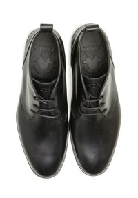 Chaussures en cuir noir avec une finition lisse, un design à lacets et une couture subtile. L'intérieur présente un logo embossé et une languette de talon contrastante.