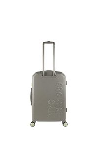 Maleta rígida gris con la inscripción en relieve "NYC EST. 1989" en el frente, asa retráctil y cuatro ruedas para facilitar su movilidad.