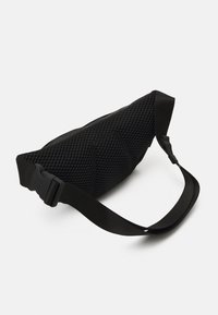 Juodas tinklinis maišelis su tekstūruotu raštu, reguliuojama dirželiu ir plastikiniu sagtimi. Kompaktiška, ergonomiška forma, skirta lengvam nešiojimui.