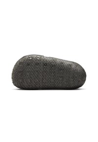 Suela texturizada negra de una zapatilla con patrones de agarre cuadrados, mostrada desde un lateral sobre un fondo blanco.