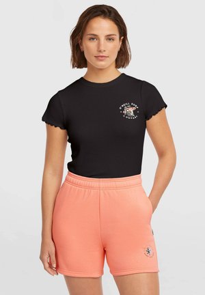 Czarny prążkowany t-shirt z falbankowymi rękawami i białym logo, zestawiony z koraloworóżowymi szortami z elastycznym pasem i akcentem logo.