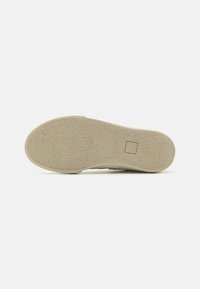 Beige rubber shoe sole with a textured surface, featuring a small square logo. The design is flat and wide.