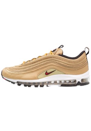 Baskets Nike Air Max 97 couleur sable avec un design ondulé, une semelle à air visible, un swoosh Nike rouge, des languettes de tirage noires et des lacets jaunes sur fond blanc.