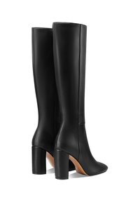 Botas de cuero negras hasta la rodilla con tacones bloques, punteras puntiagudas y una textura suave, con un detalle de cremallera lateral.