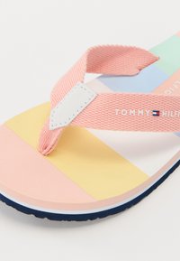 Infradito colorati con una fascia in tessuto rosa e suola di gomma. Presenta una soletta a motivi multicolori in tonalità pastello con un accento blu navy.