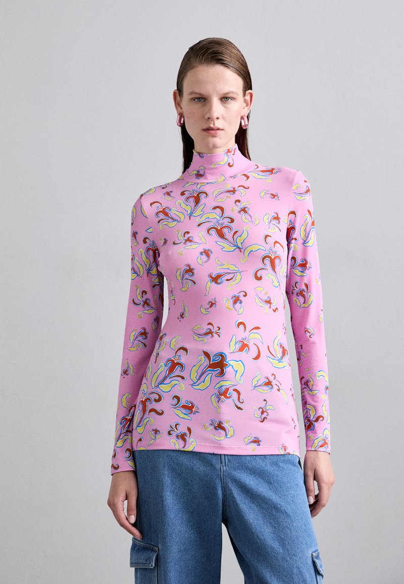 Langarm, hoge hals top in roze stof met een kleurrijk abstract spiraalpatroon. Gladde textuur met levendige tinten van rood, blauw en groen.