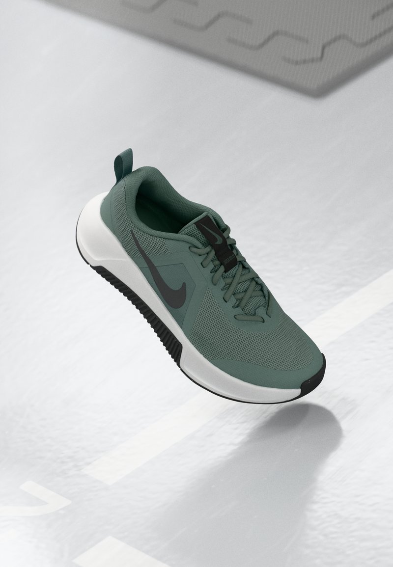 Pantofii sport din plasă verde au un detaliu Swoosh negru, o talpă intermediară albă și o talpă exterioară texturată neagră; prezintă un design cu șireturi și un tab de călcâi.