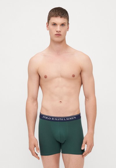 Zöld pamut boxer alsónadrág sötétkék derékkal, amelyen a "POLO RALPH LAUREN" logó található. Minimalista dizájn, sima textúra és testhezálló sziluett jellemzi.